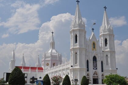 Front view of the Velankanni Temple with a tall Gothic architectural building and its area.