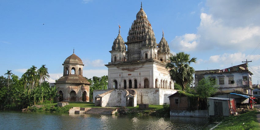 A picture of a traditionally built Hindu temple on the bank of a river flowing in front