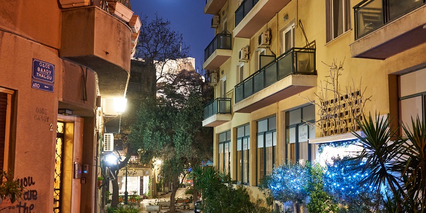 Street of Chairefontos in Plaka at night with buildings, balconies and air conditioners.