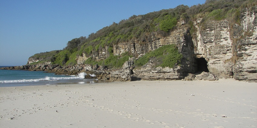 Rocky cliffs and hidden sea caves at Caves Beach