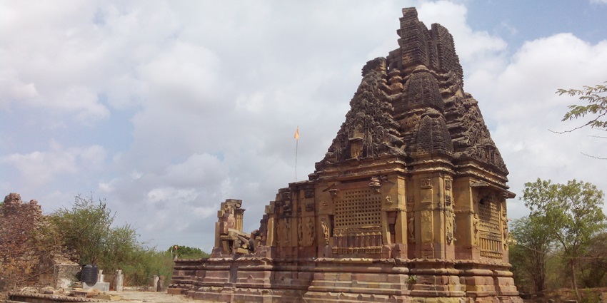 Image of an ancient temple surrounded by lush green forest during day time view