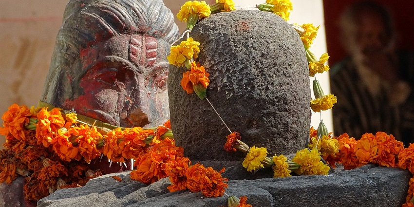 A picture of a stone sculpture at a Devi Temple in Allahabad, decorated in garlands and flowers