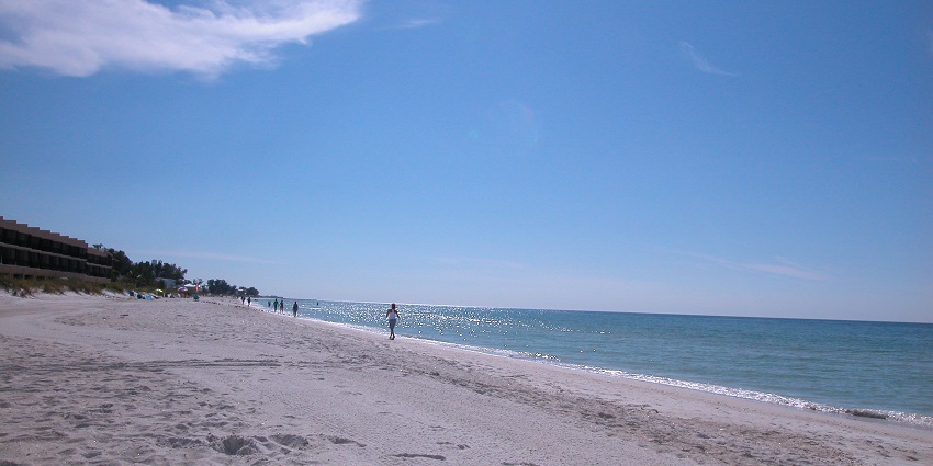 An image of Anna Maria Island with clear waters, white sand, and gentle waves