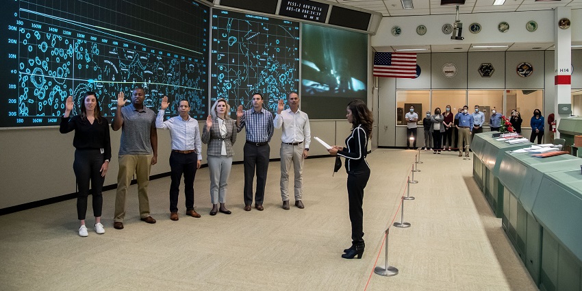 The gallery astronaut candidates swearing in and standing in uniform during a ceremony.