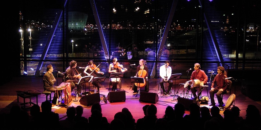 Image of a Dutch band performing on the stage in Amsterdam, with the crowd jamming along.