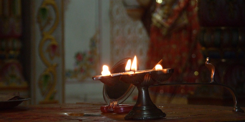 An image of devotees participating in the morning aarti at Kalighat Temple, with priests.