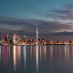 A view of the Vibrant streets of Auckland during night time and reflecting on the lake water