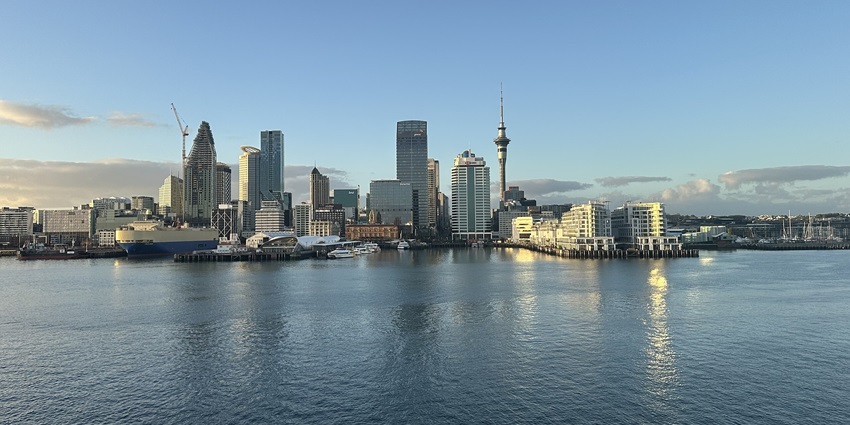 A picture of the majestic skyline of Auckland, taken from the sea, under a clear sky