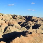 An image of the Badlands National Park covered by the blue sky and white clouds.