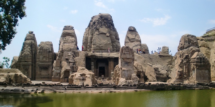 A vibrant view of a temple carved into a large rock.