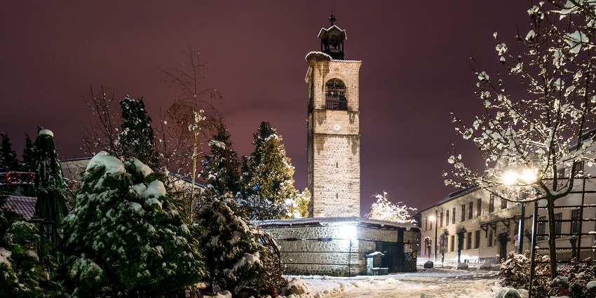 Bansko Street with trees and buildings covered in snow and multiple streetlights