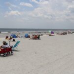 An image of beaches in Jacksonville Florida and distant buildings under a clear sky.