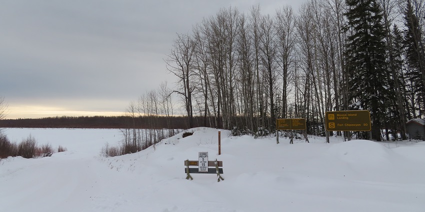 A winter road leading through a snowy landscape to Moose Island Landing in Alberta, Canada.