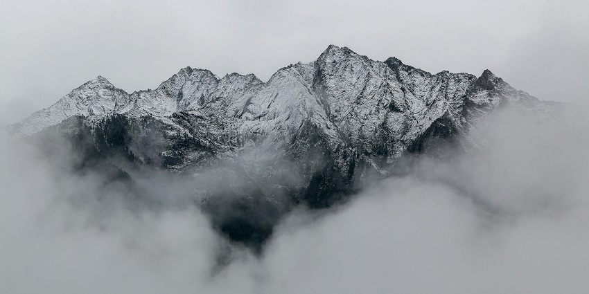 Snow-covered mountains with rocky peaks and snowy ridges create a majestic alpine landscape.