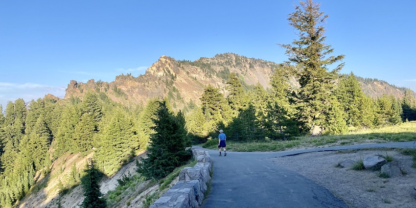 An image showcasing the mountains and trees along with visitors at the National Park.