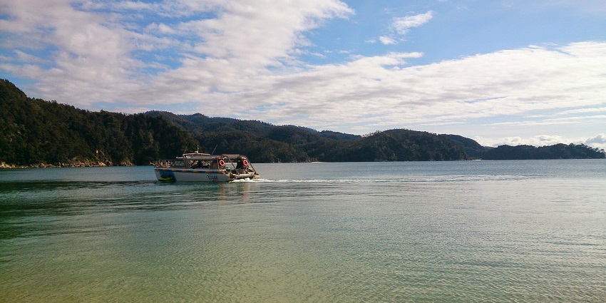 Tourists enjoying boat rides on the lake near Abel Tasman National Park in New Zealand.