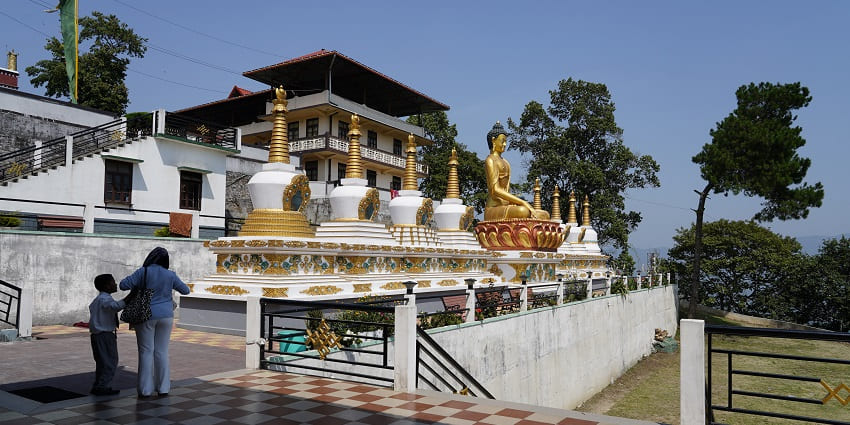 An image of Tharpa Choling Monastery featuring traditional Buddhist architecture.