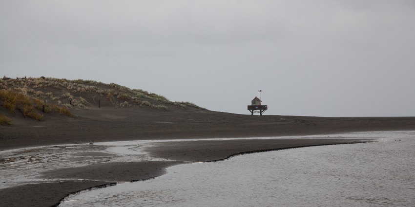 One of the hidden gems with black sand and cliffs, unique among the peaceful beaches.