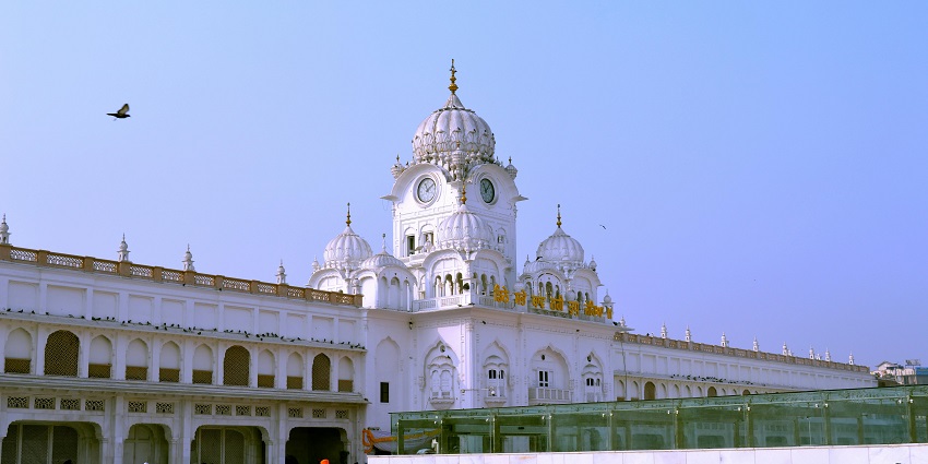 An image of Dharma Singh Gurudwara in Hastinapur with multiple domes and a clock tower