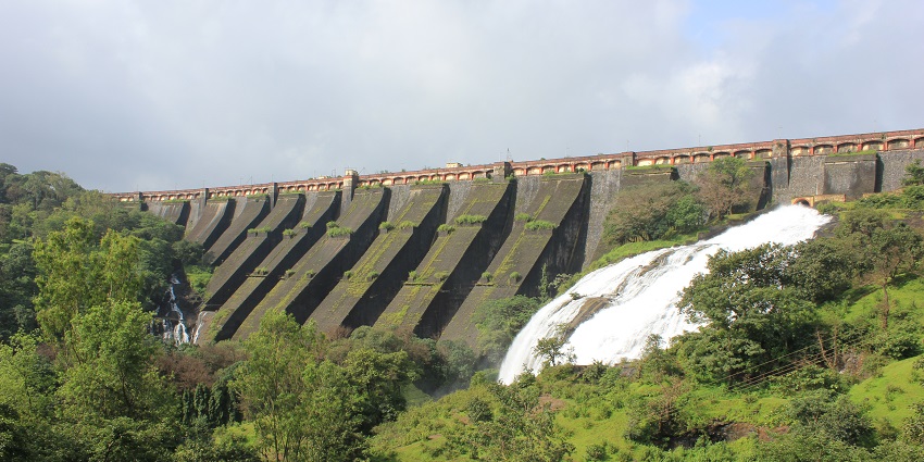 A scenic view of Wilson Dam amidst lush greenery in Bhandardara trekking.