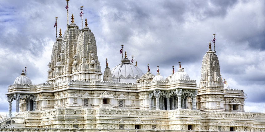 An image of a Hindu temple with ornate architecture and statues, featuring intricate carvings.