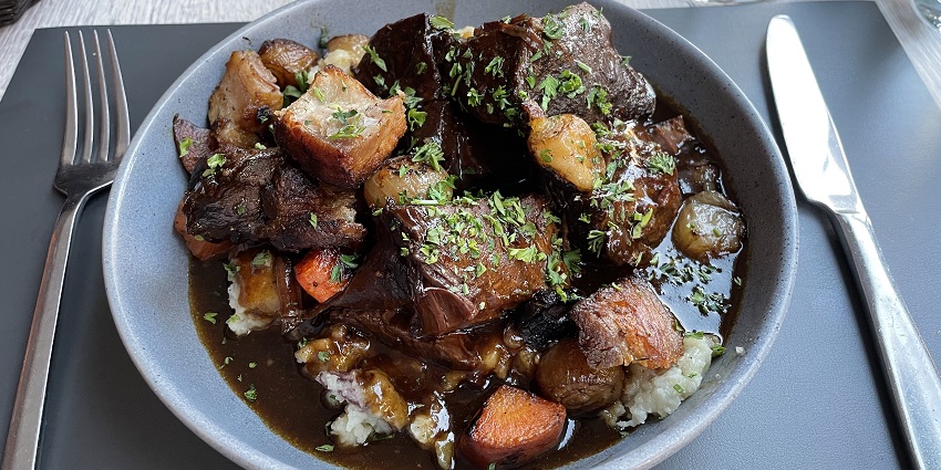 Hearty beef stew slow-cooked in red wine and vegetables at At Le Bistrot Paul Bert.