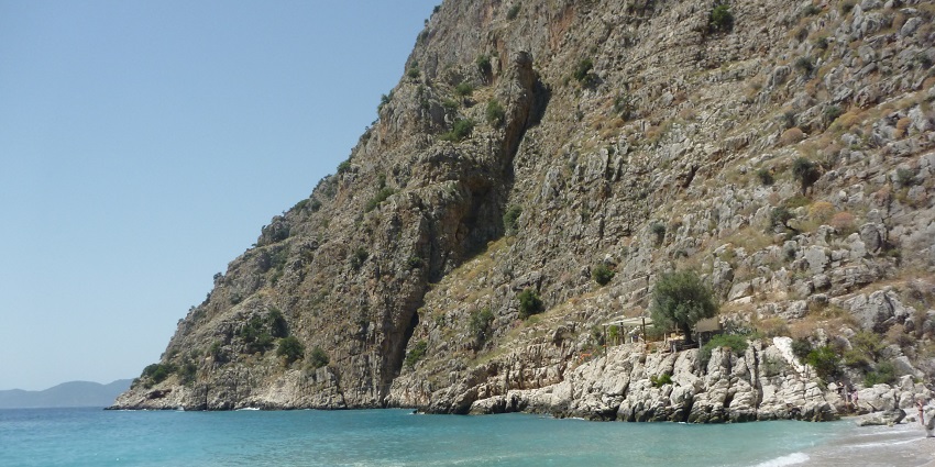 Cliffs surrounding the pristine beach, accessible via boat or hike.