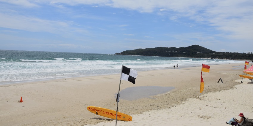 People walking at Byron Bay which is one of the most-visited beaches in Australia.