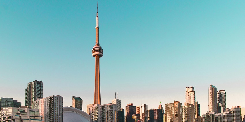 An inside view of the CN Tower where people are observing the city from the glass window.