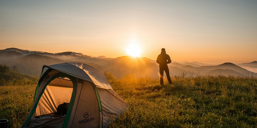 Image of campers enjoying a night under the stars surrounded by towering rock formations.