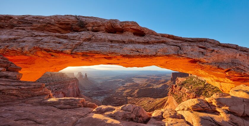 Sunrise through Mesa Arch at Canyonlands National Park, showcasing vibrant orange skies.