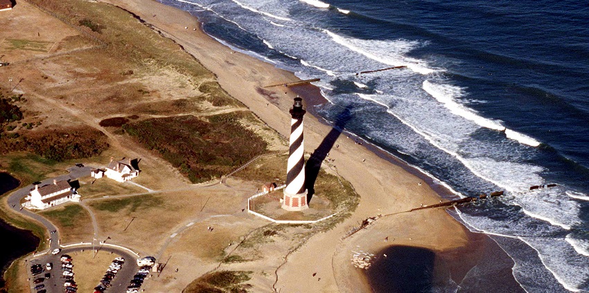 Iconic Cape Hatteras Lighthouse with black-and-white stripes against a clear blue sky.