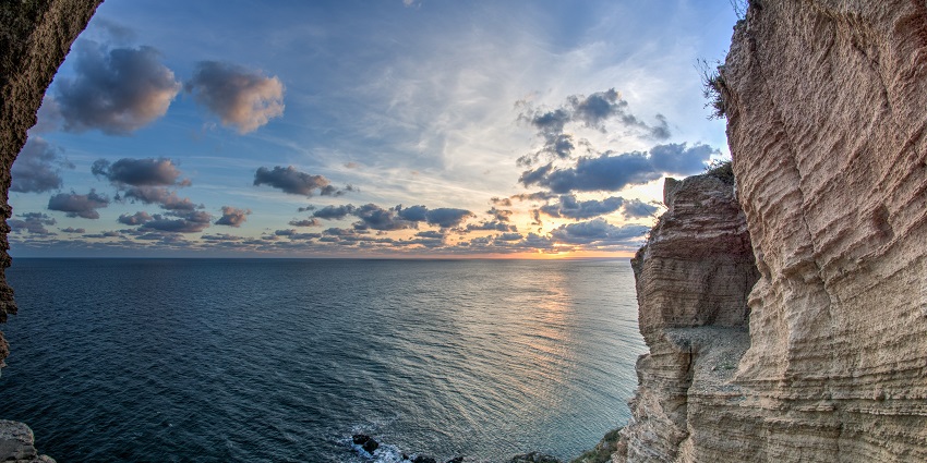 Cape Kaliakra with stony shoreline and cliffs, a vast calm ocean during sunset