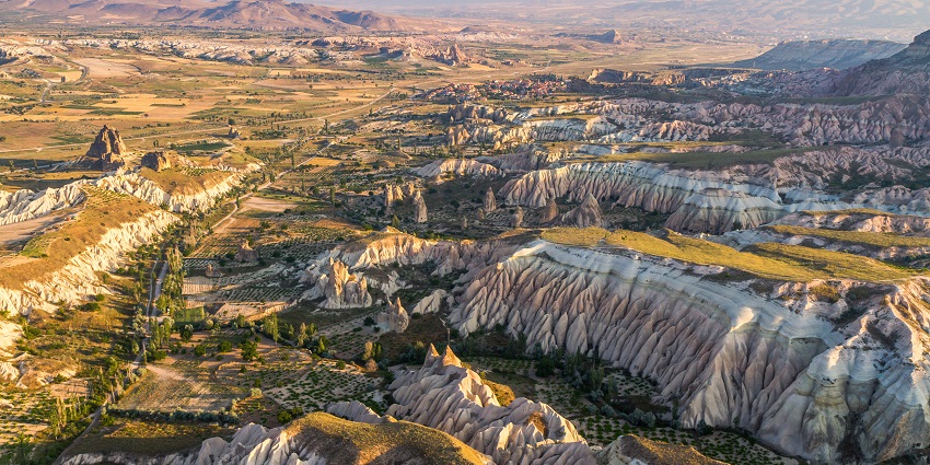 Unique landscape while paragliding in Turkey with fairy chimneys, caves, and balloon rides.