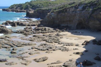 Waves crashing against rock formations at scenic Caves Beach