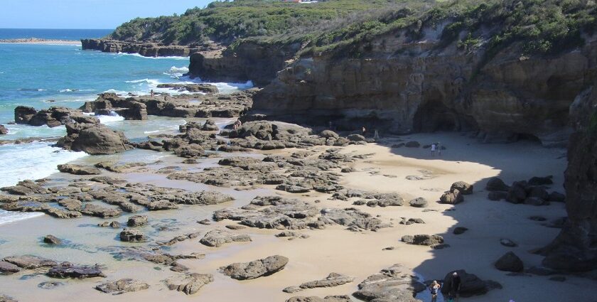 Waves crashing against rock formations at scenic Caves Beach