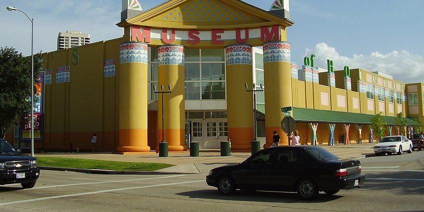 A frontal view of a children's Museum with yellow exteriors and a castle-like architecture