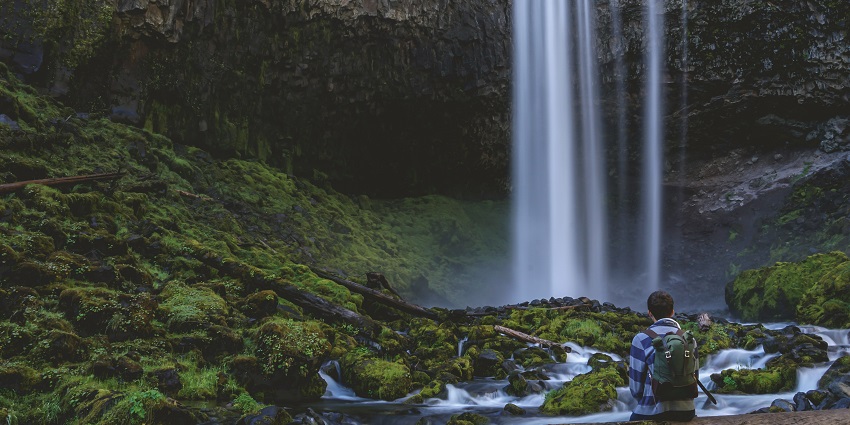 A picture of the majestic Chinnakallar Falls cascading down the rocks surrounded by greenery.