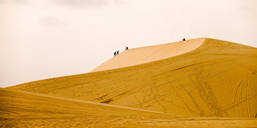 Exhilarating activity scaling towering dunes in the scenic desert.