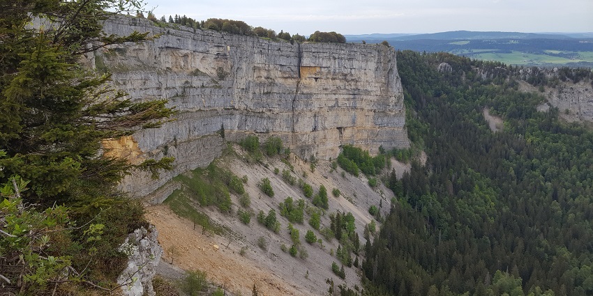 Hike Creux du Van's rugged trails, scenic views abound.
