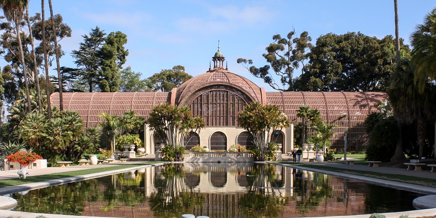 A view of the Botanical Park Building of Balboa Park with a water reservoir in front.