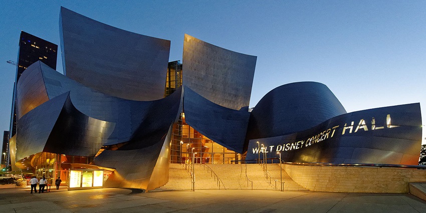 Outside of Walt Disney Concert Hall with metallic structures and the name illuminated