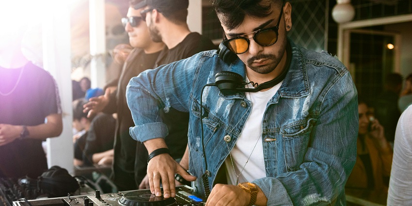  A picture of a man playing music, and showing the best to do to experience Penthouze nightlife.