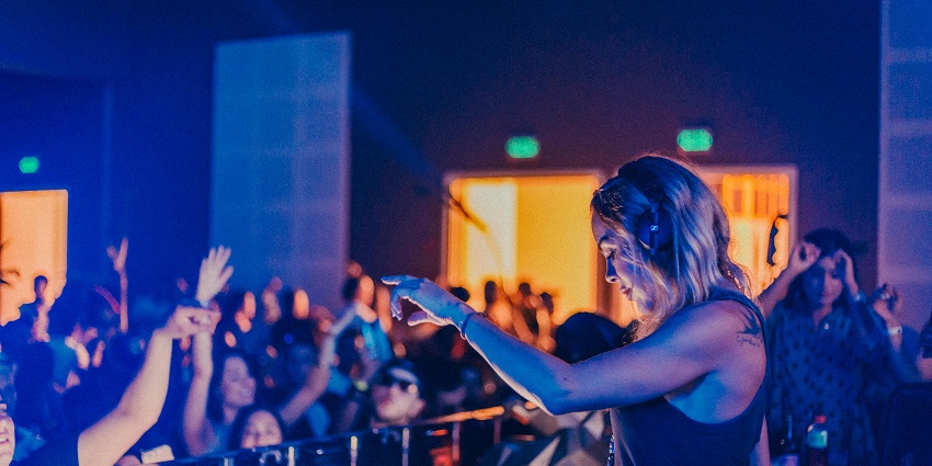 Iamge of a woman DJ playing music - Popular pub with craft beers, cocktails, and a DJ set