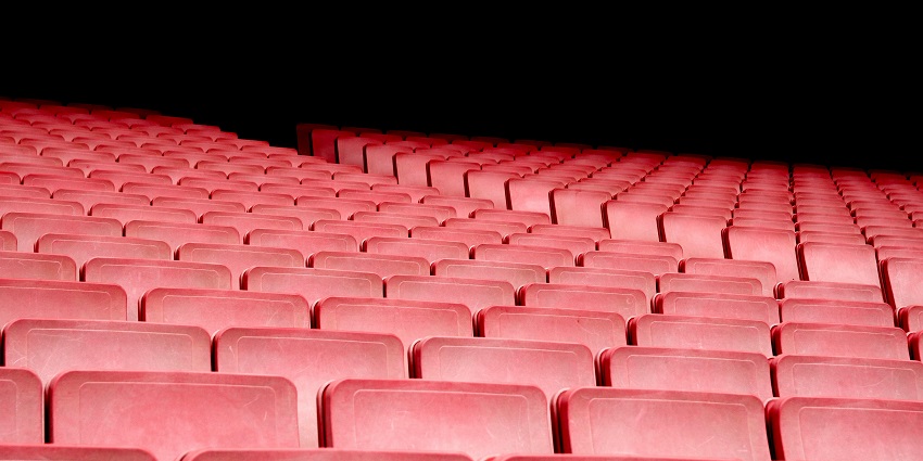 A group of people in an auditorium who can be seen watching a documentary.