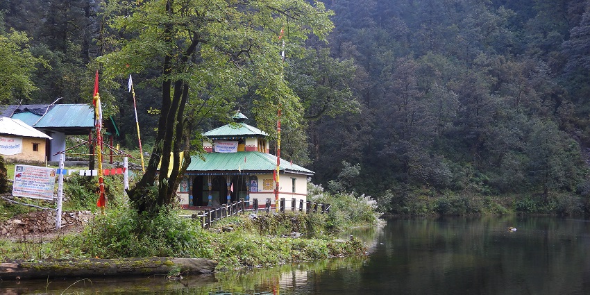 Serene Dodital Lake surrounded by mountains and forests near Uttarkashi Temple.