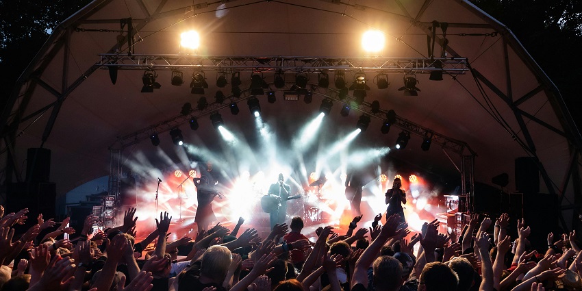 The band performed on the stage in eject festival with the drummer playing instruments.