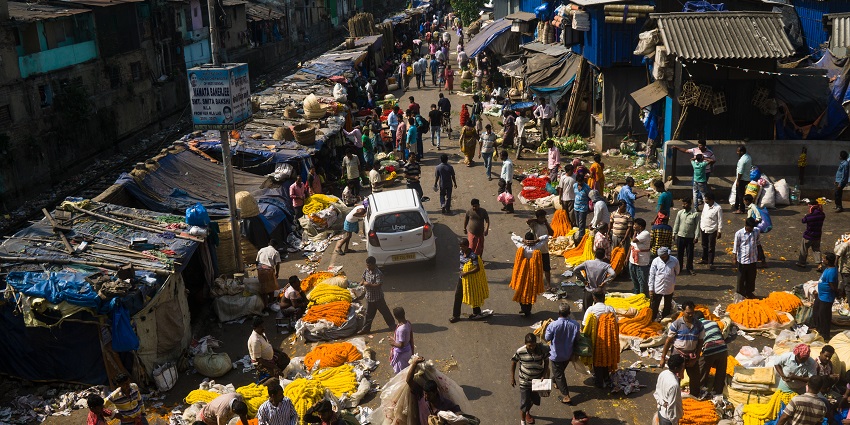 An image of the local market around Kalighat Temple featuring vendors selling religious items.