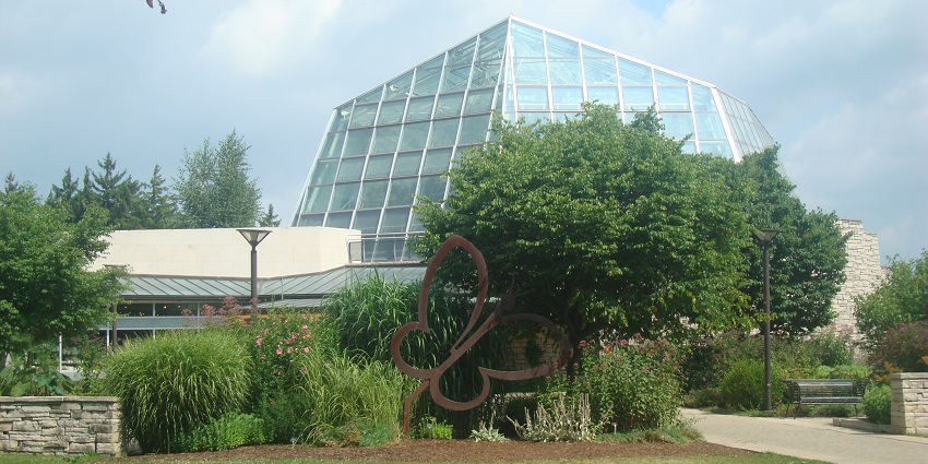 A steel frame depicting a butterfly in a garden in front of Niagara Falls Butterfly Conservatory.