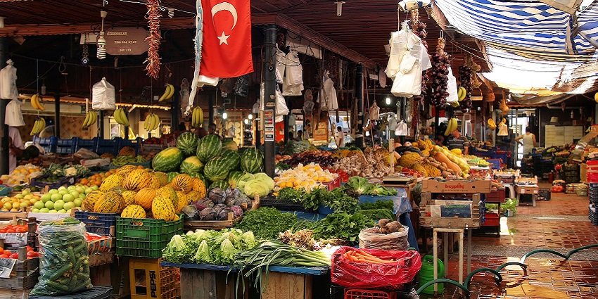 Vibrant outdoor market offering fresh produce, goods, and souvenirs